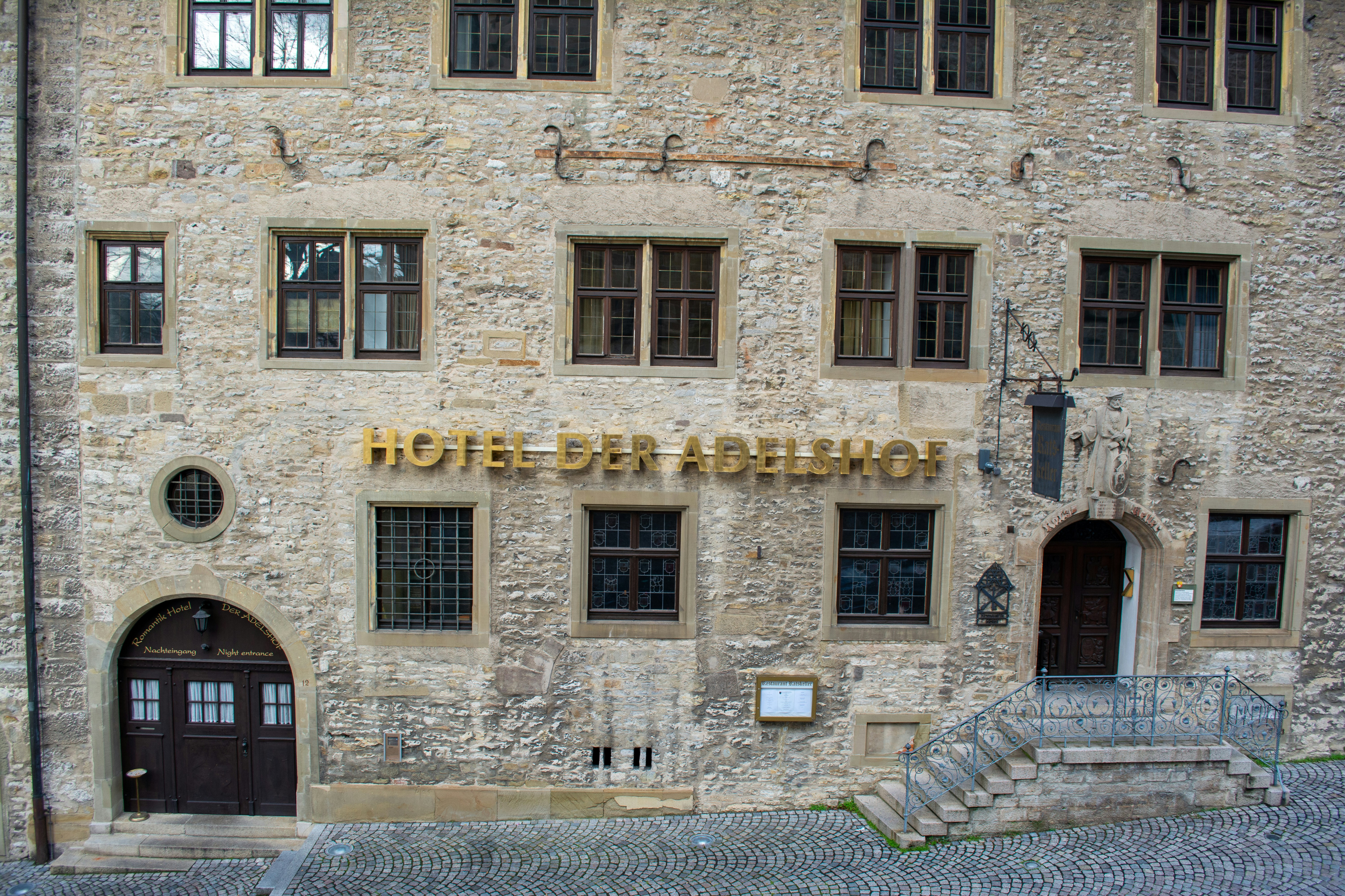 a stone building with a hotel sign on it's side