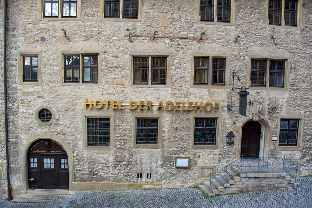 a stone building with a hotel sign on it's side