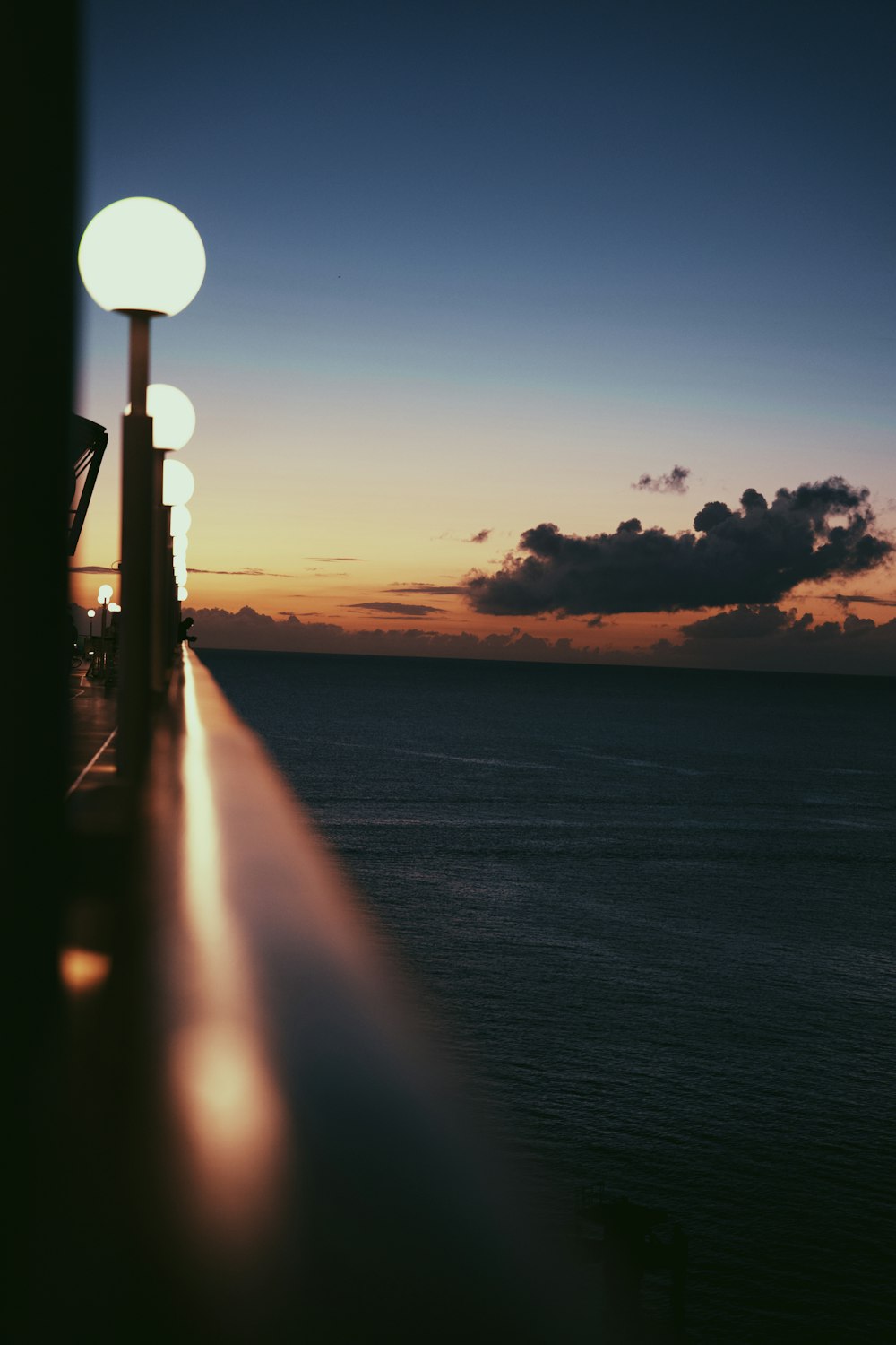 a view of the ocean from a balcony at sunset