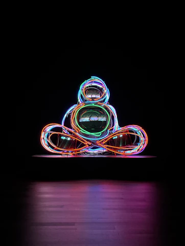 A striking neon green abstract sculpture glowing against a pitch-black background, embodying cyber-brutalism.