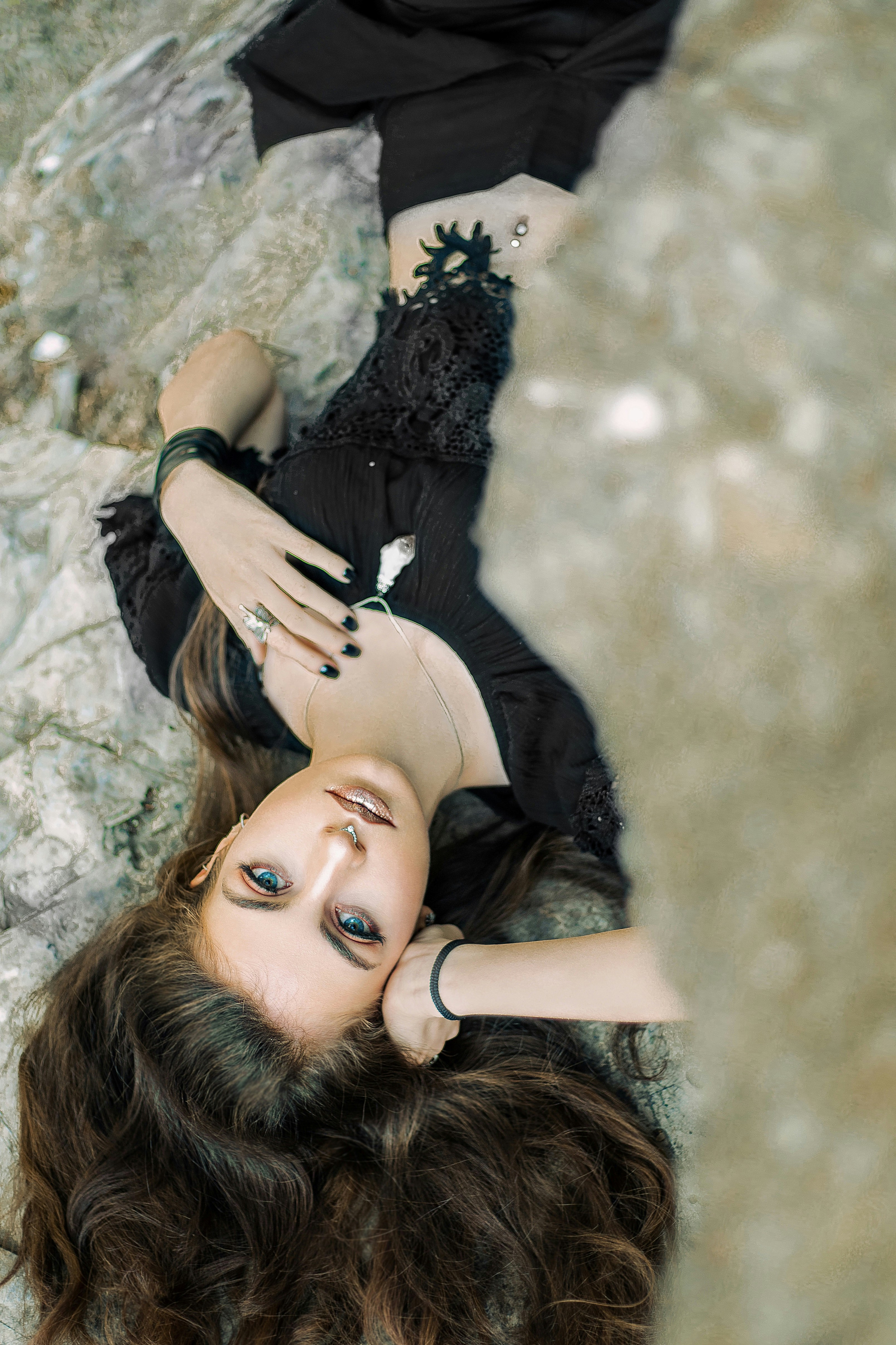a woman laying on top of a rock