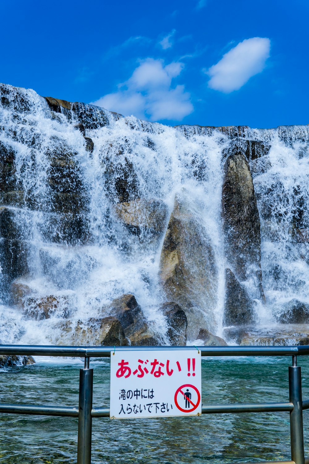 a sign warning people not to enter the waterfall