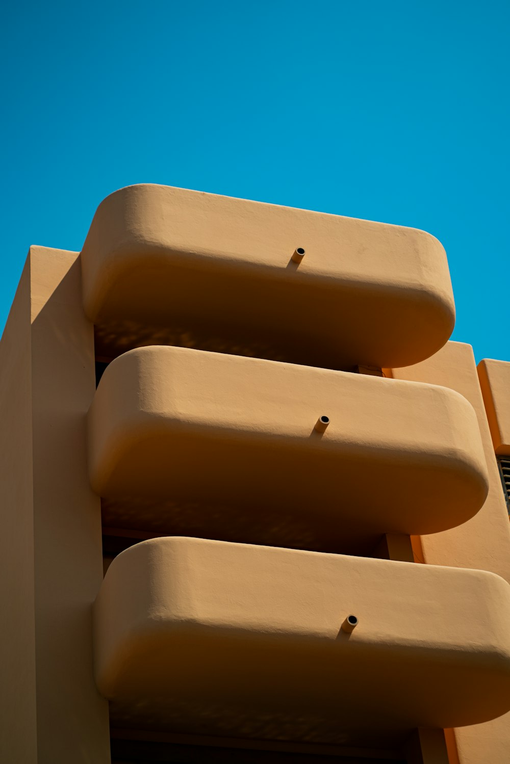 a tan building with a blue sky in the background