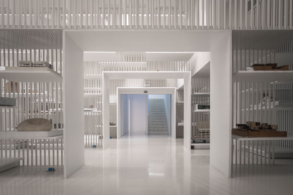 a long white hallway with white walls and shelves