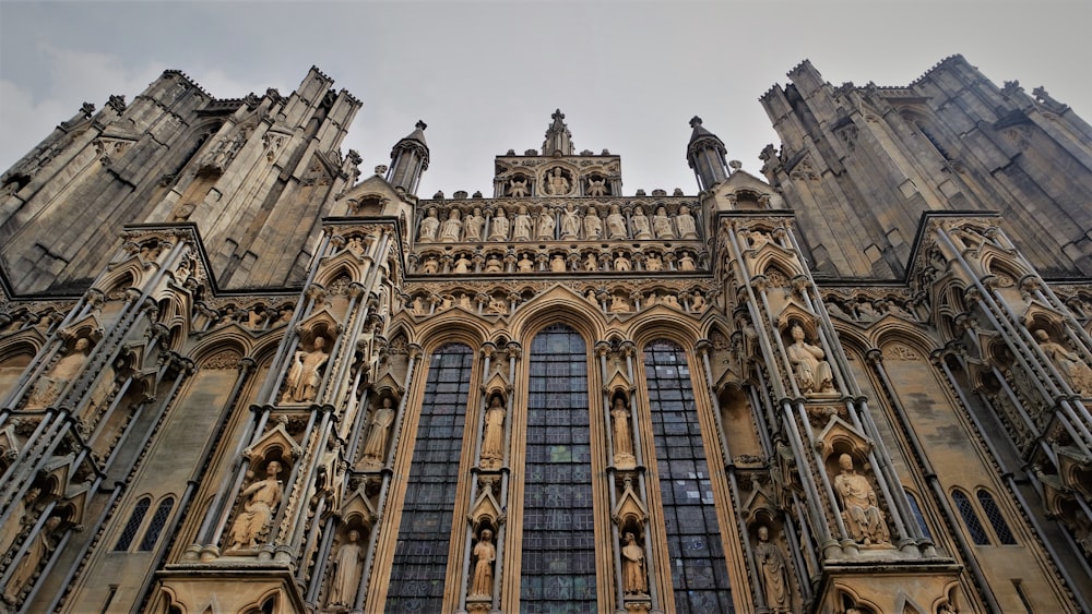 a very tall building with many windows and statues on it