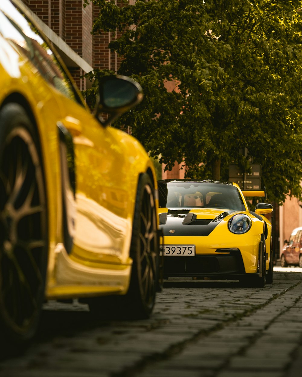 a yellow sports car driving down a street