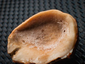 Close-up of old coconut shells ready for charcoal production, highlighting their texture and natural state.
