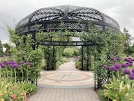 A charming garden gazebo surrounded by blooming flowers and greenery.
