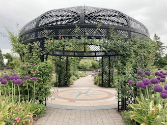 A charming garden gazebo surrounded by blooming flowers and greenery.