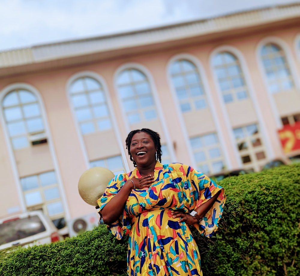 a woman standing in front of a building holding a balloon