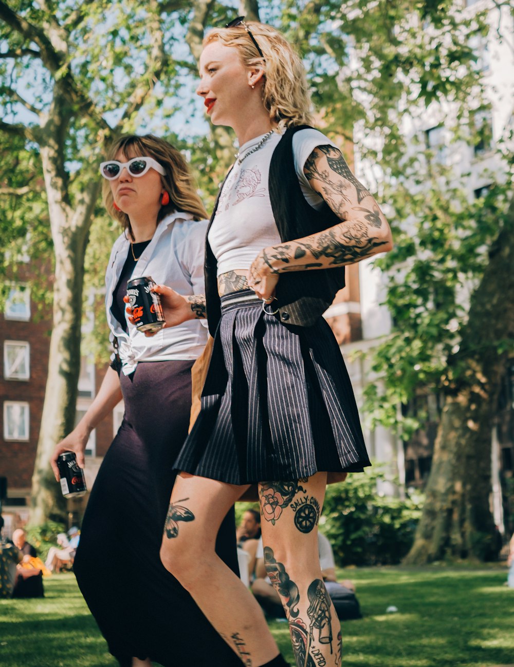 a couple of women walking across a lush green park