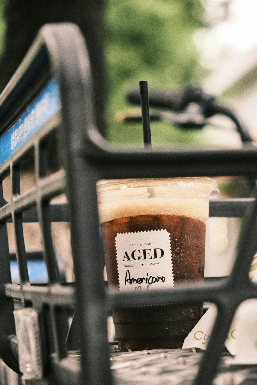 a cup of iced coffee sitting on a bench