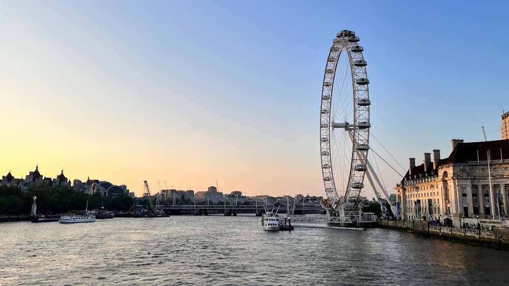 a large ferris wheel sitting next to a river