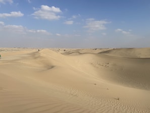 a truck is driving through the sand dunes
