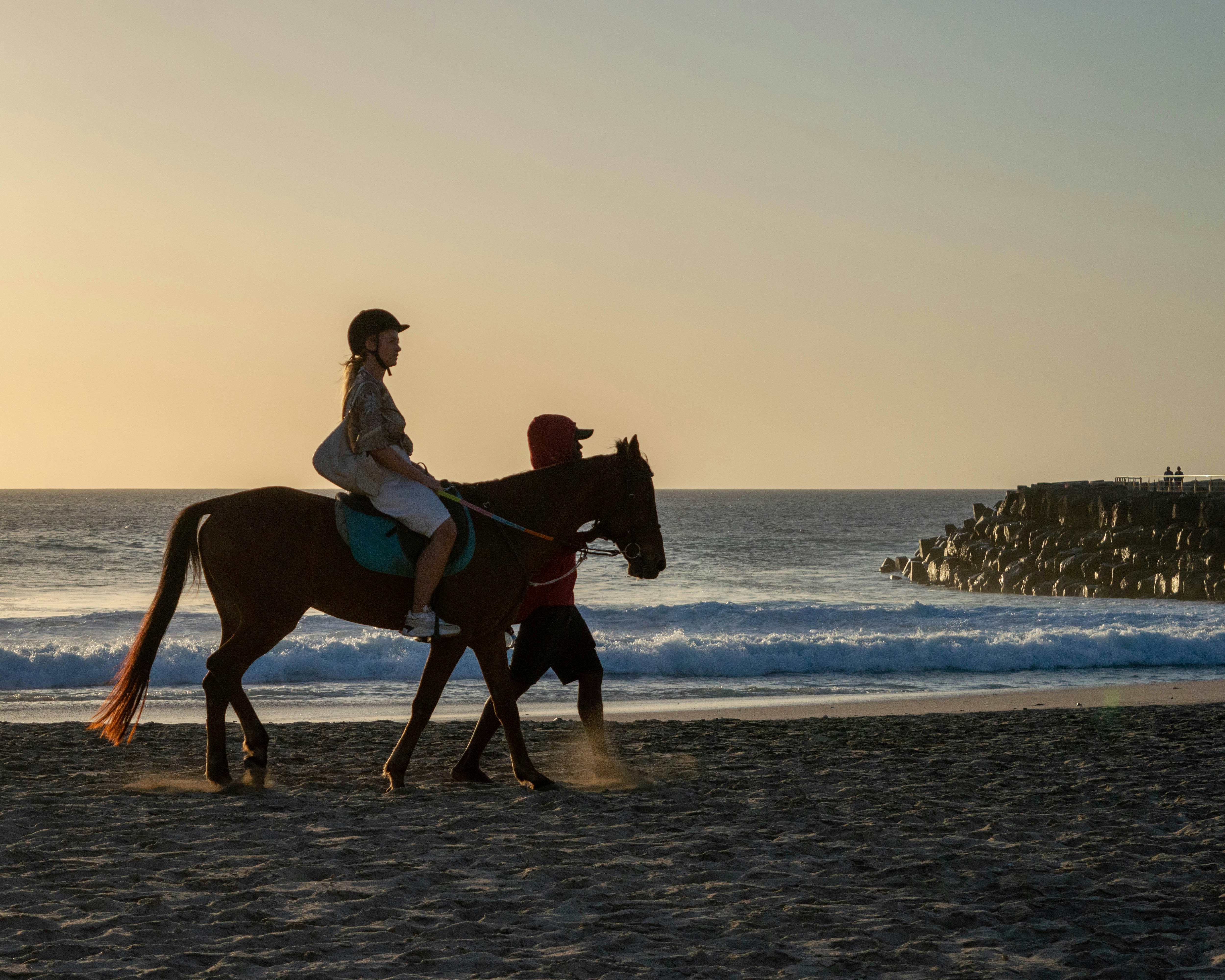 a woman riding on the back of a brown horse