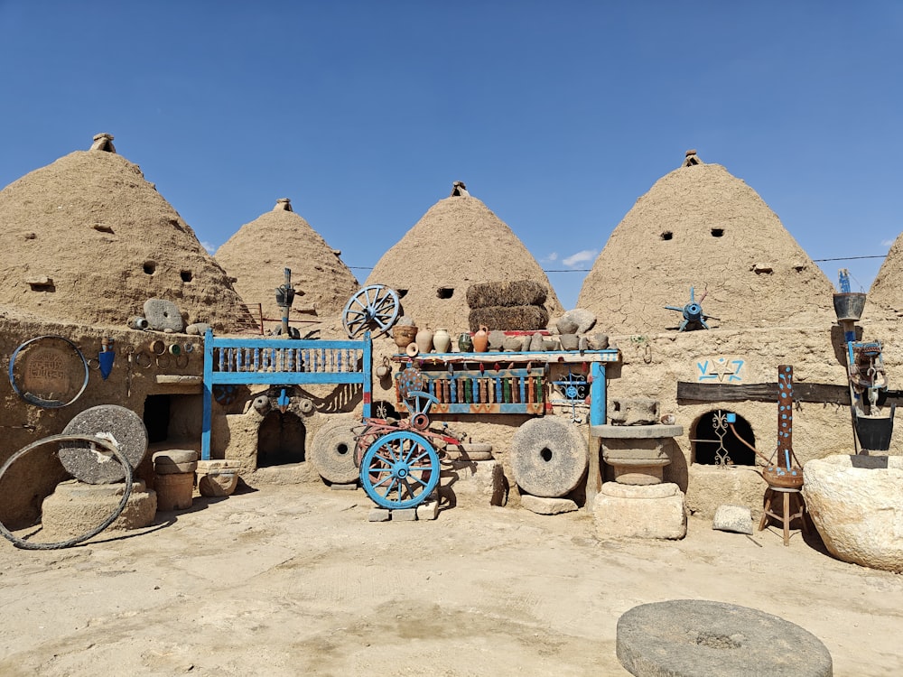 a group of stone buildings with a blue cart in front of them