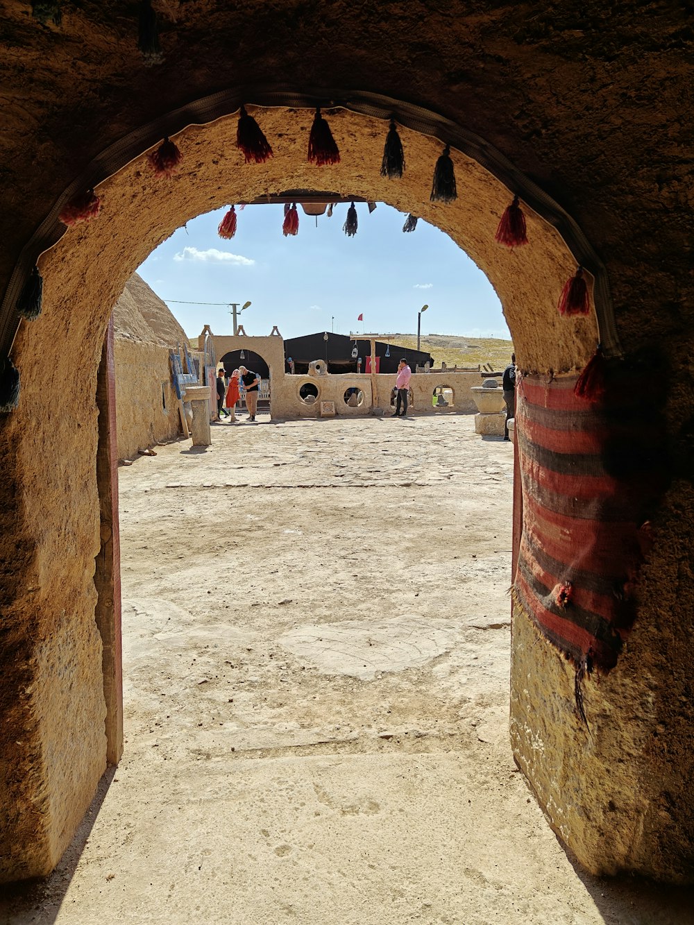 an archway leading into a desert with a sky background