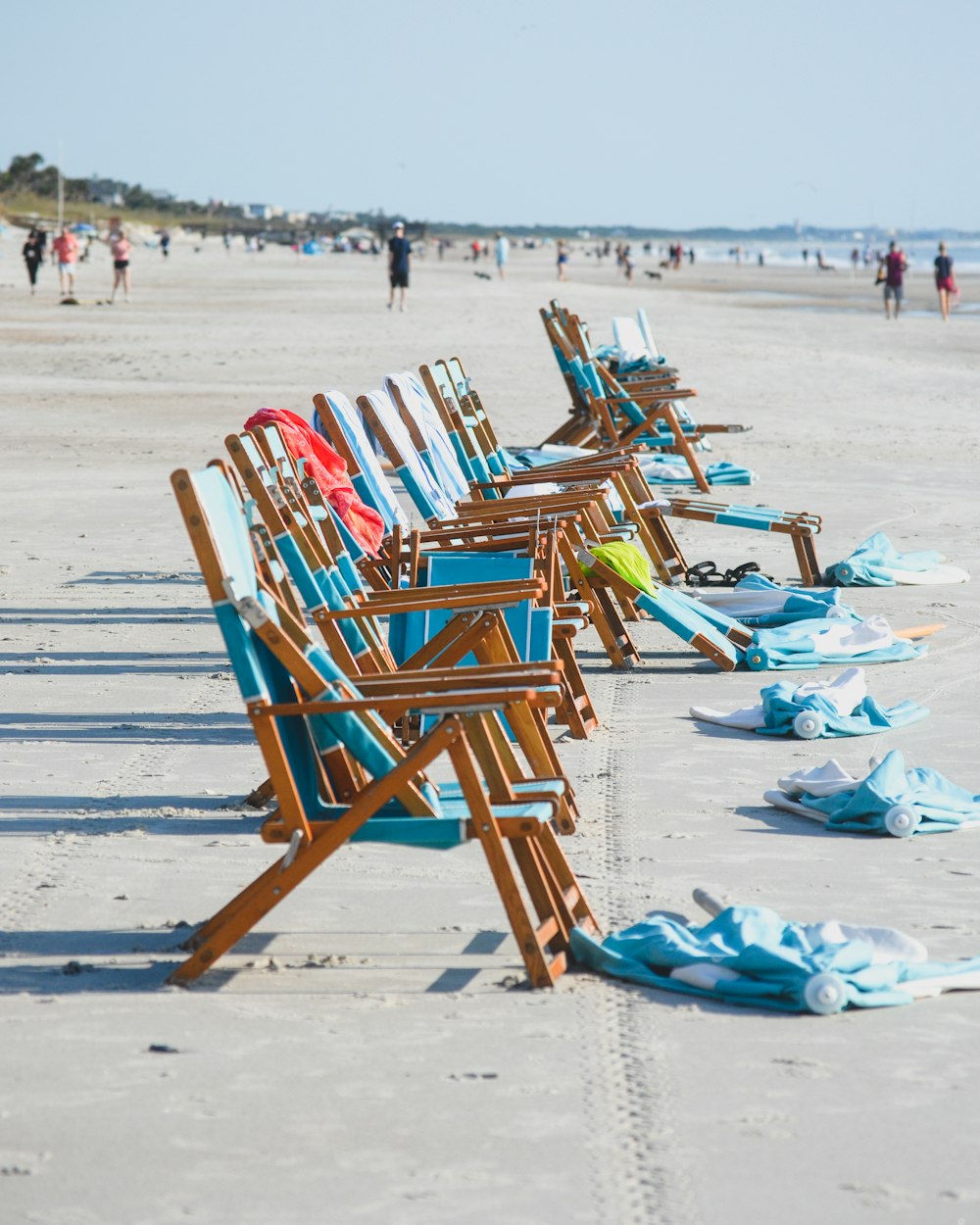 모래 사장 위에 앉아 있는 해변 의자 한 줄