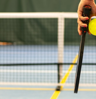 a person holding a tennis ball and a racket