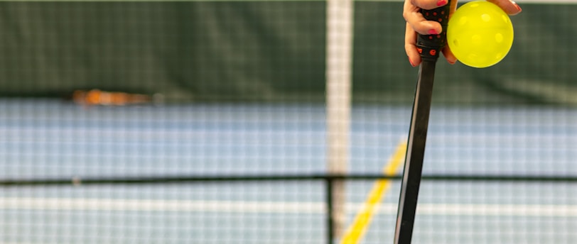 a person holding a tennis ball and a racket