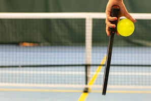 a person holding a tennis ball and a racket