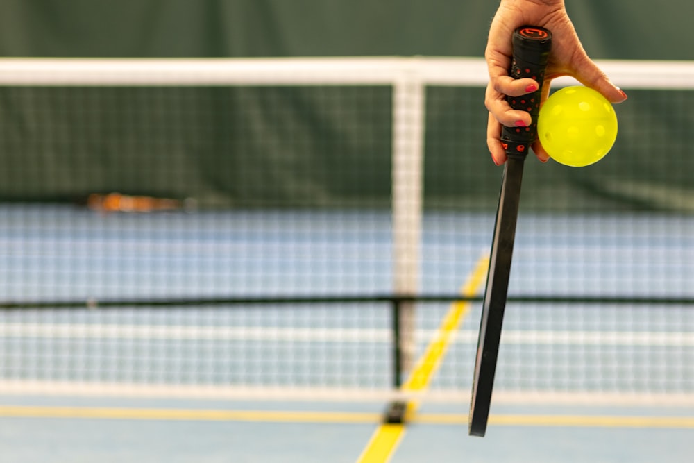 a person holding a tennis ball and a racket