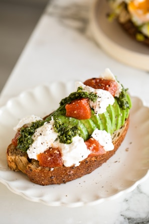 A fresh avocado toast garnished with cherry tomatoes and microgreens.