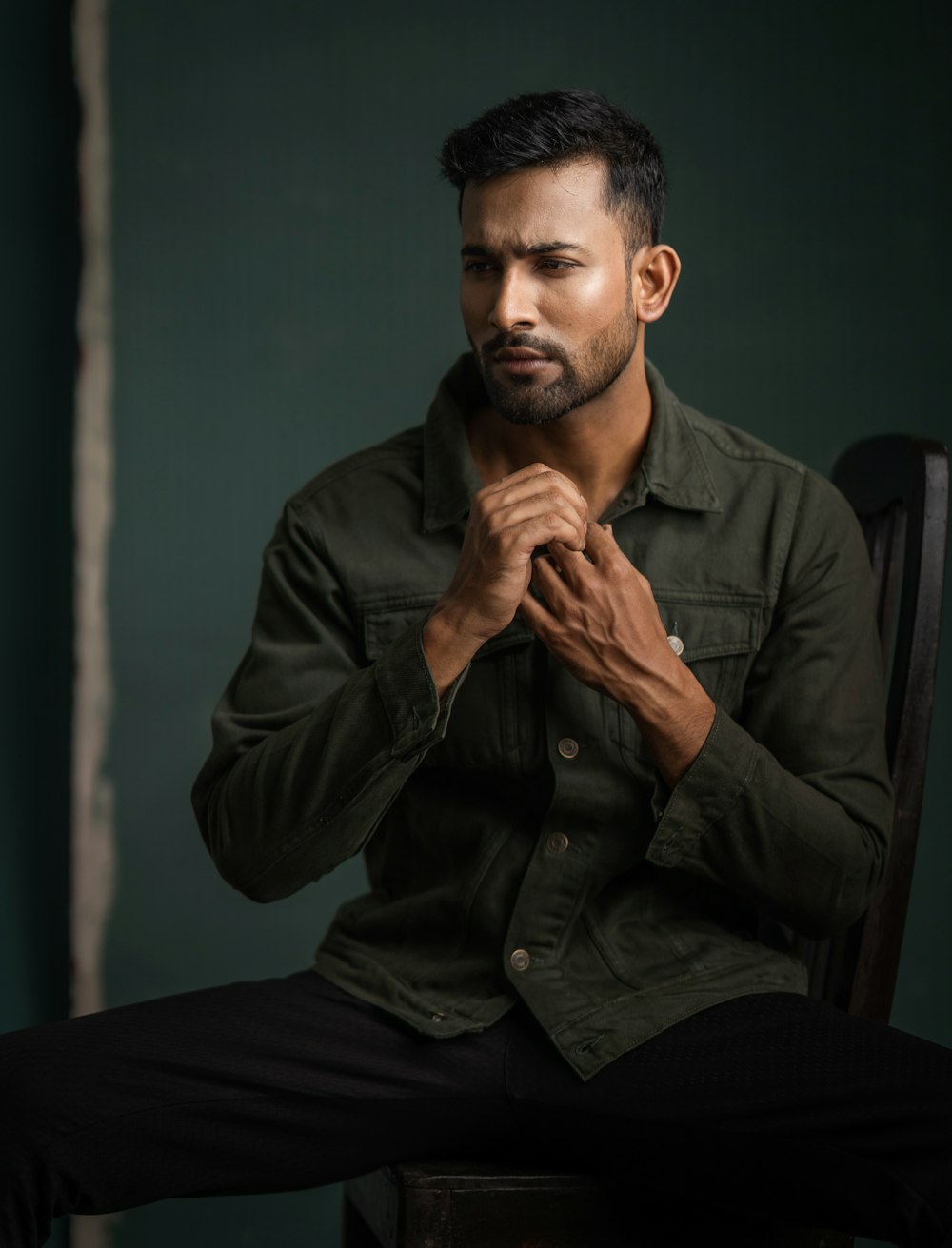 a man sitting in a chair with his hands clasped