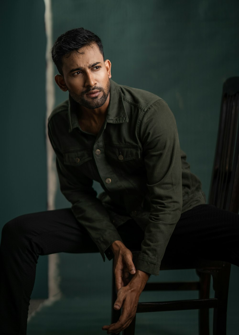 a man sitting on a chair in a green room