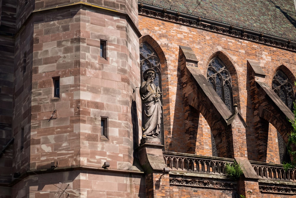 un grand bâtiment en briques avec une statue sur le côté