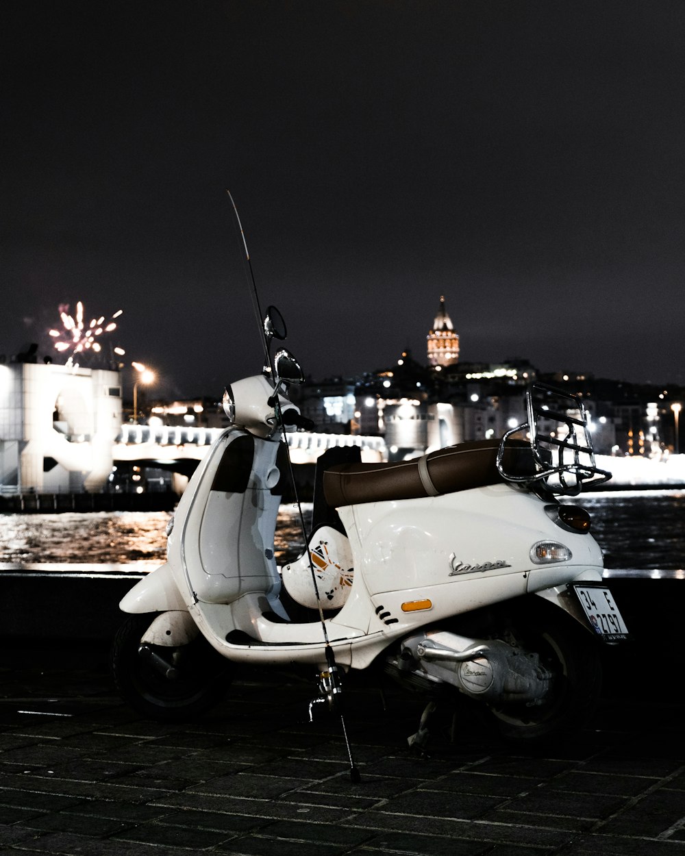 a white scooter parked next to a body of water