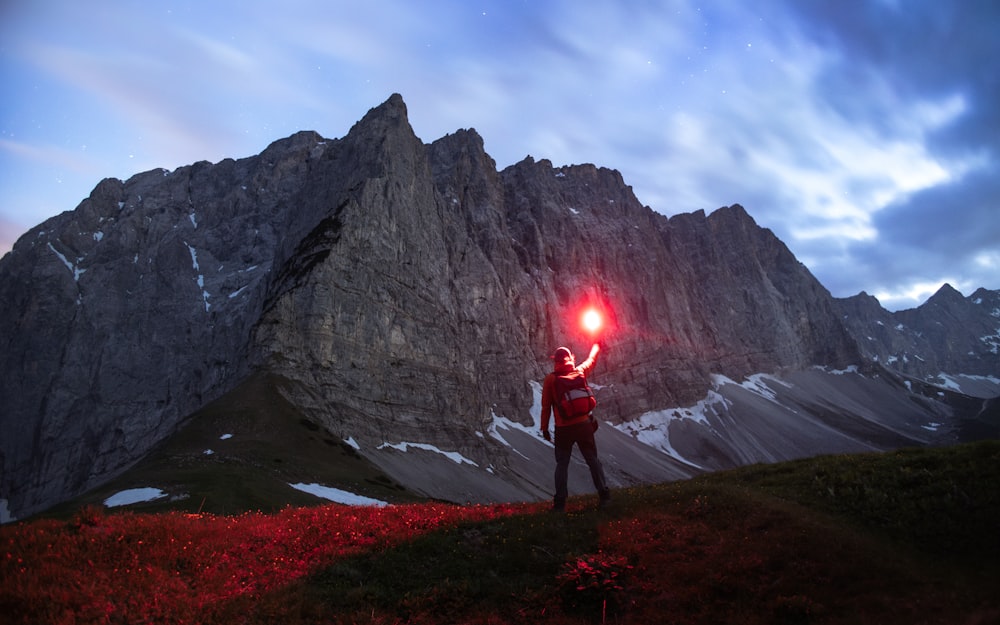 a man holding a red light up in the air