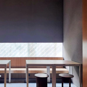 A commercial space furnished with minimalist tables and chairs, highlighting clean lines