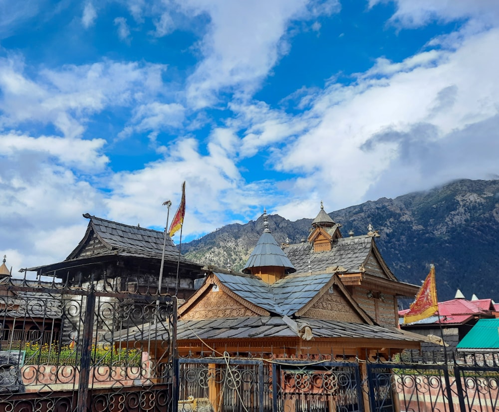 a building with a fence and a mountain in the background