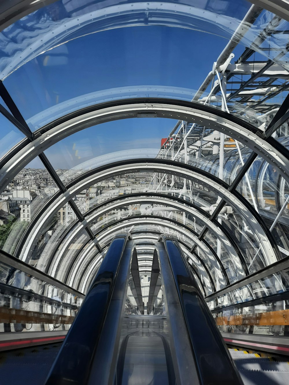 an escalator in a building with a view of a city