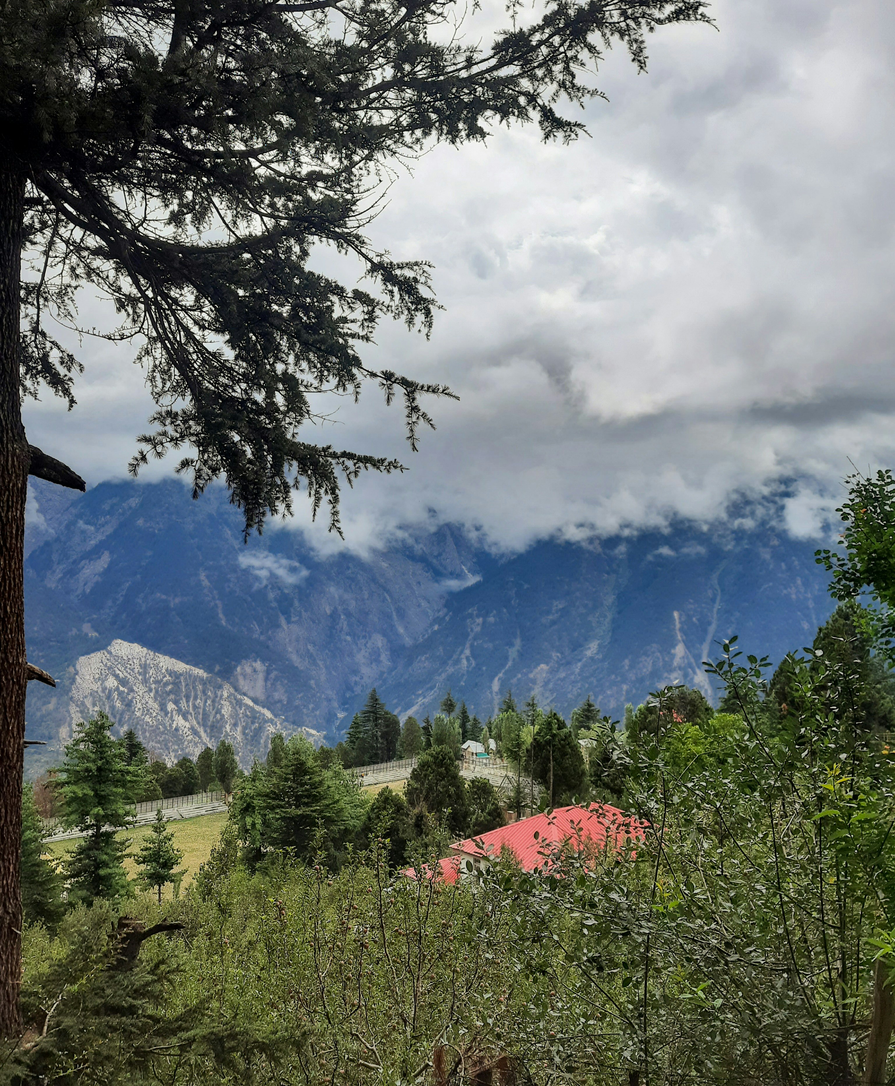 A view of a mountain range with a red barn in the foreground photo ...