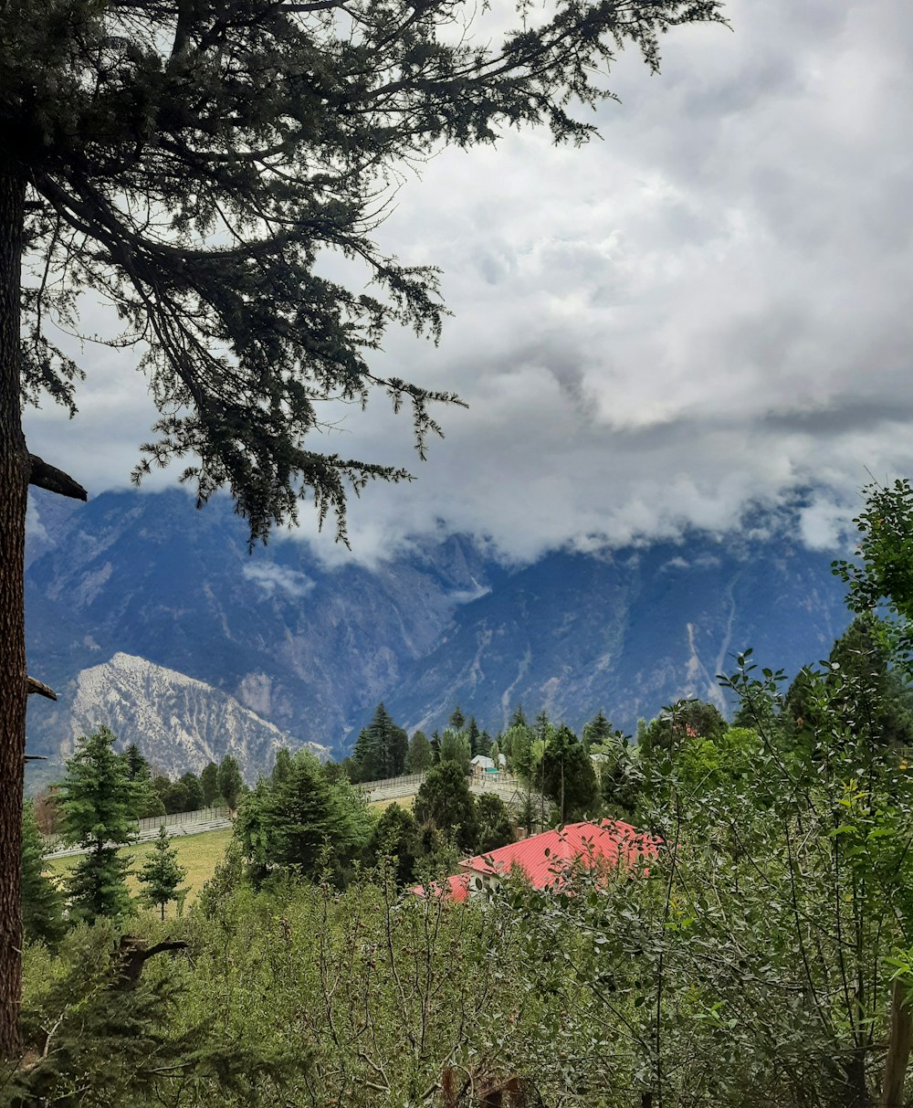 a view of a mountain range with a red barn in the foreground