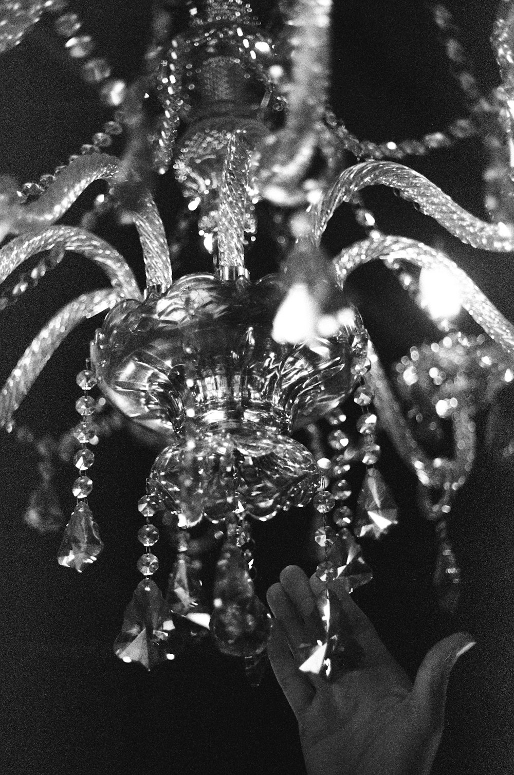 a hand is holding a crystal chandelier in black and white