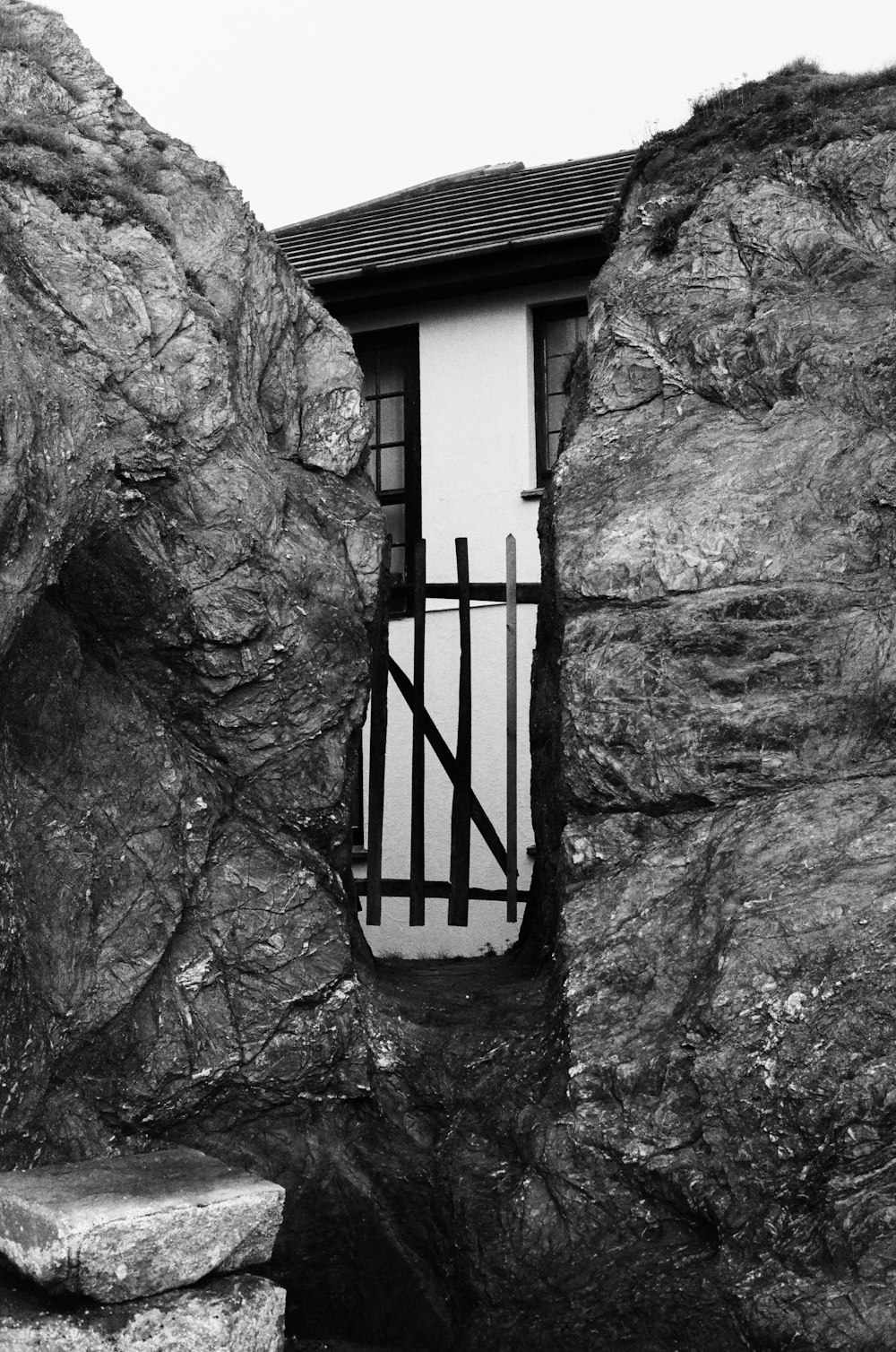 a black and white photo of a door in a rock