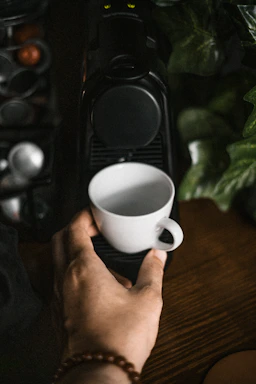 A cozy coffee machine corner with a warm cup steaming beside a clear, modern contact form on a desk.