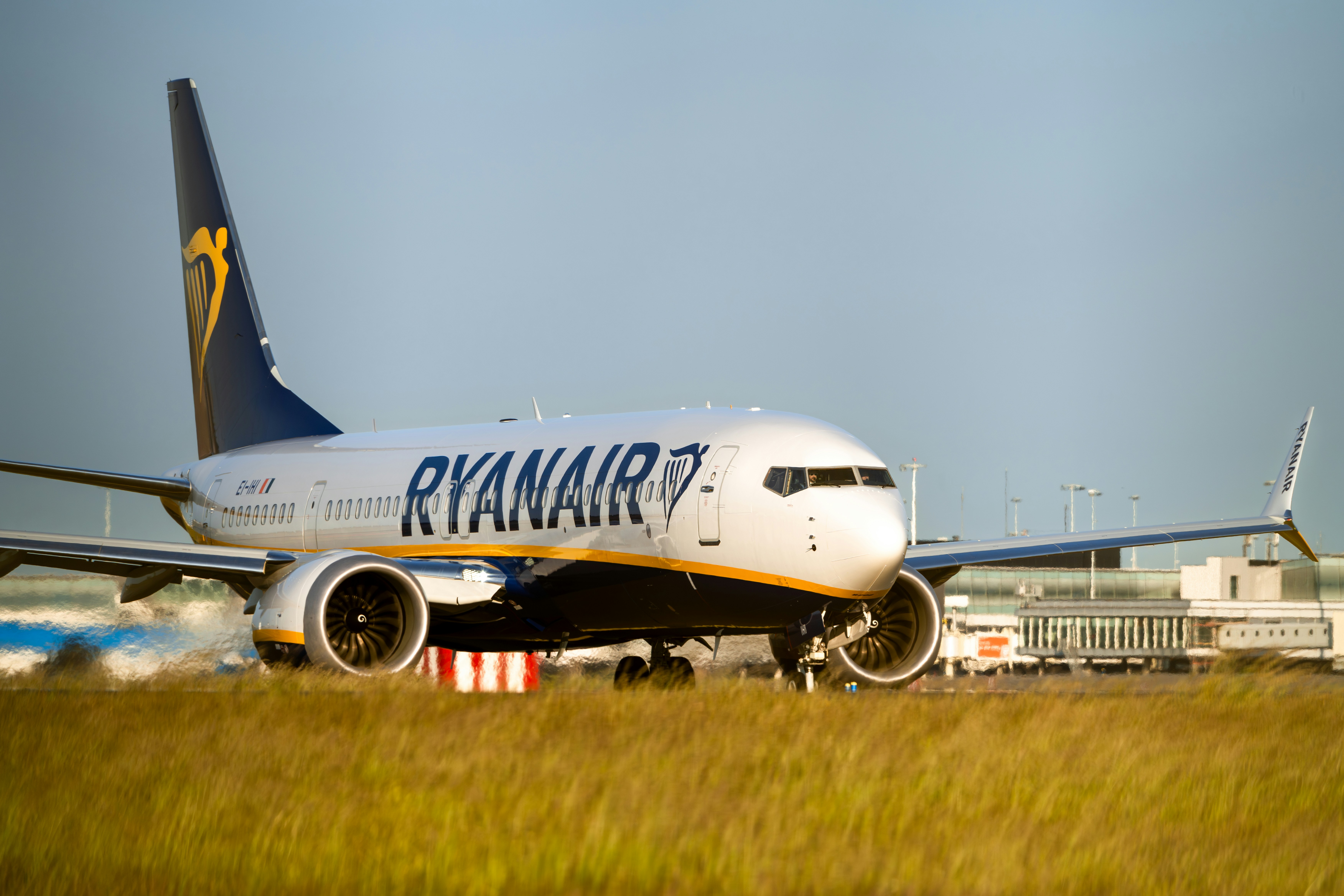 a large jetliner sitting on top of an airport runway, Ryanair flight FR3101 to Dublin (a Boeing 737 MAX 8-200, reg. EI-IHI) taxiing to the Polderbaan runway at Schiphol airport for departure.