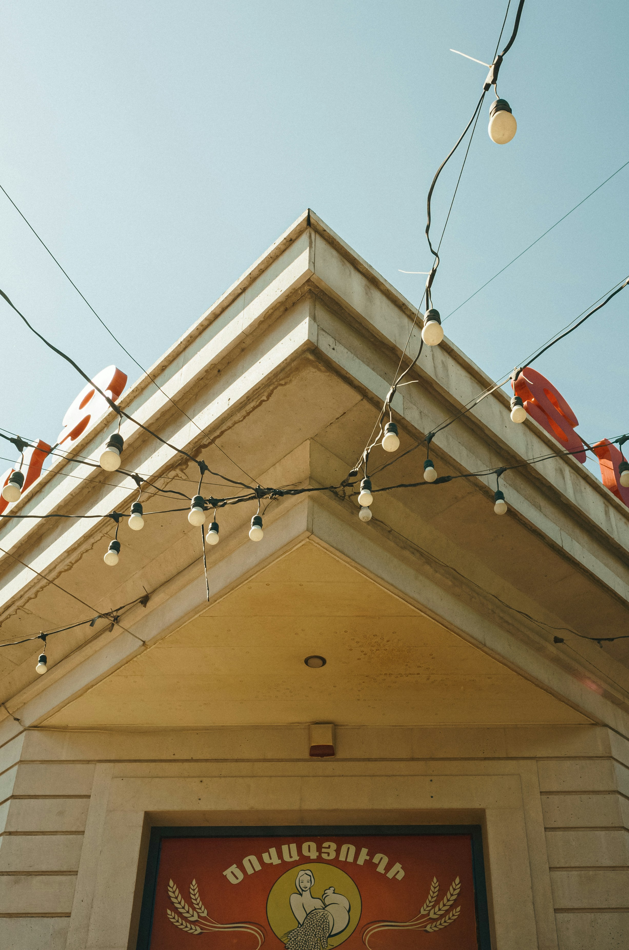 a building with a sign and lights hanging from it's roof