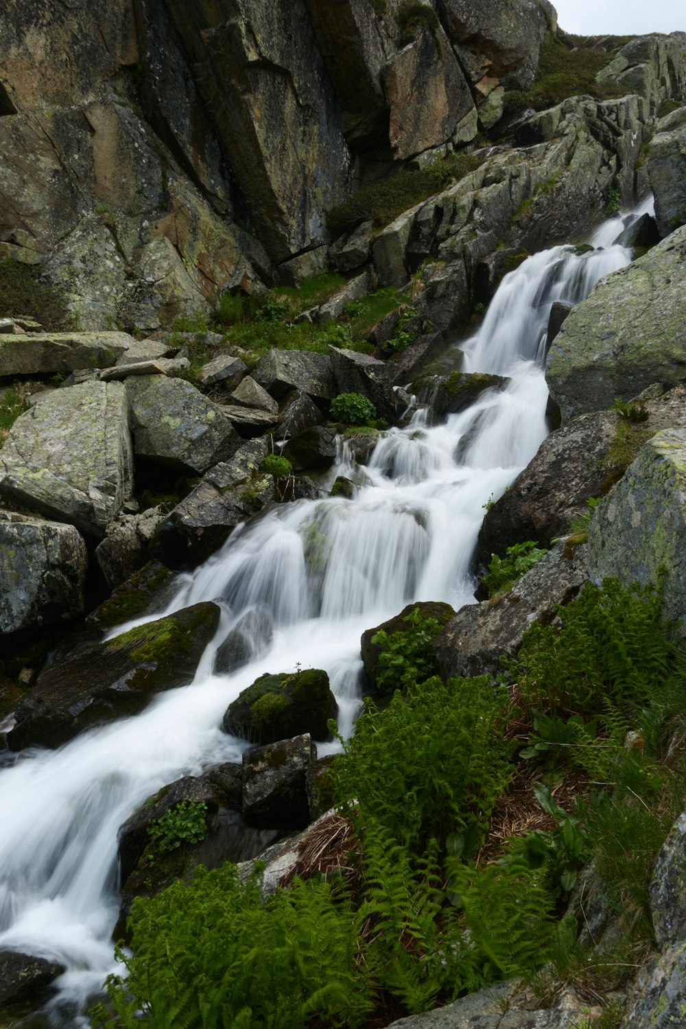 a stream of water running down a rocky hillside