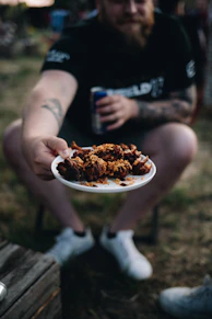 a man holding a plate of food in his hands