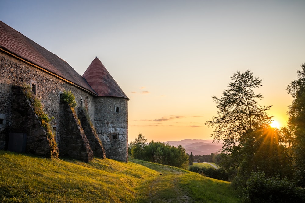 Un bâtiment en pierre assis au sommet d’une colline verdoyante