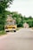 A candid photo of Bruce smiling beside his vintage school bus on a sunny Kansas afternoon.