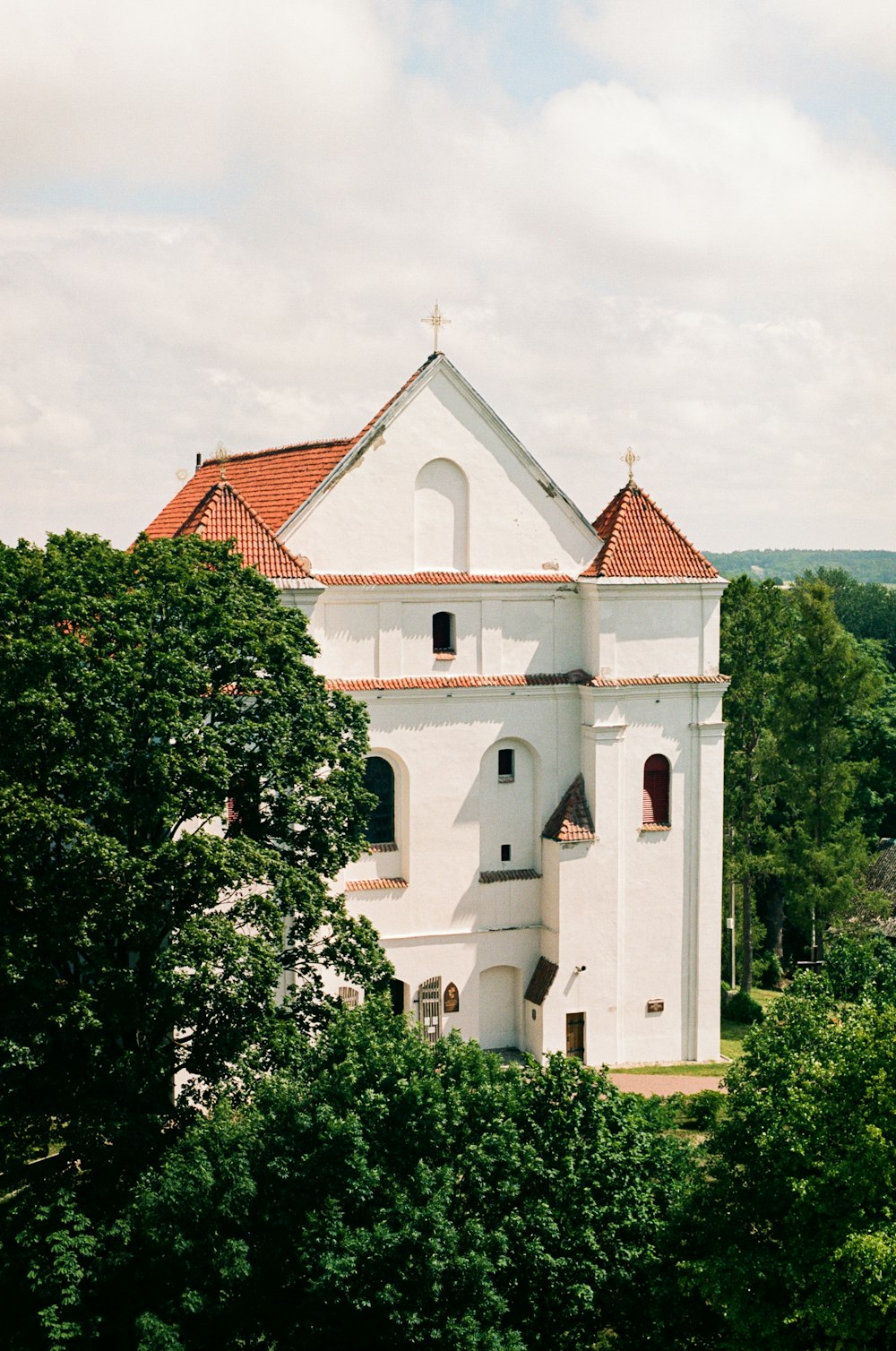 eine weiße Kirche mit rotem Dach, umgeben von Bäumen