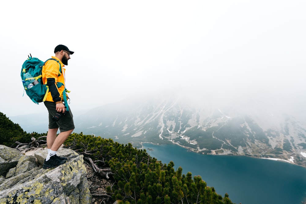 a man standing on top of a mountain with a backpack