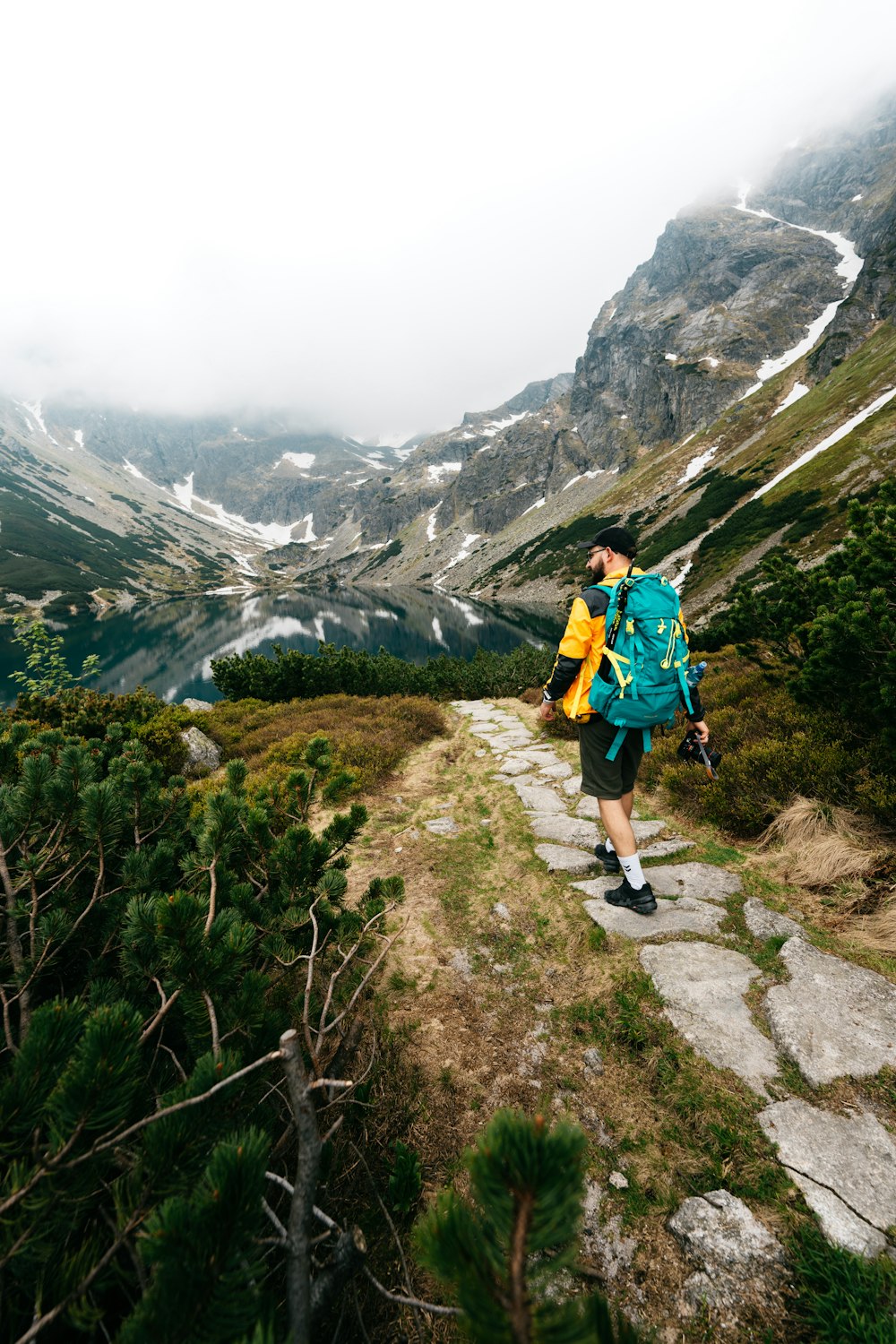 a man with a backpack walking up a mountain trail