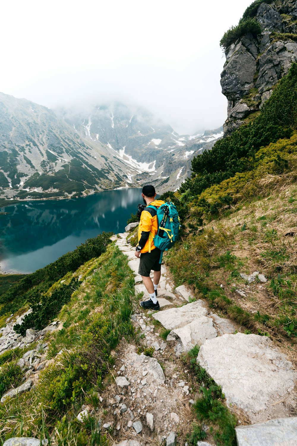 a man with a backpack is hiking up a hill